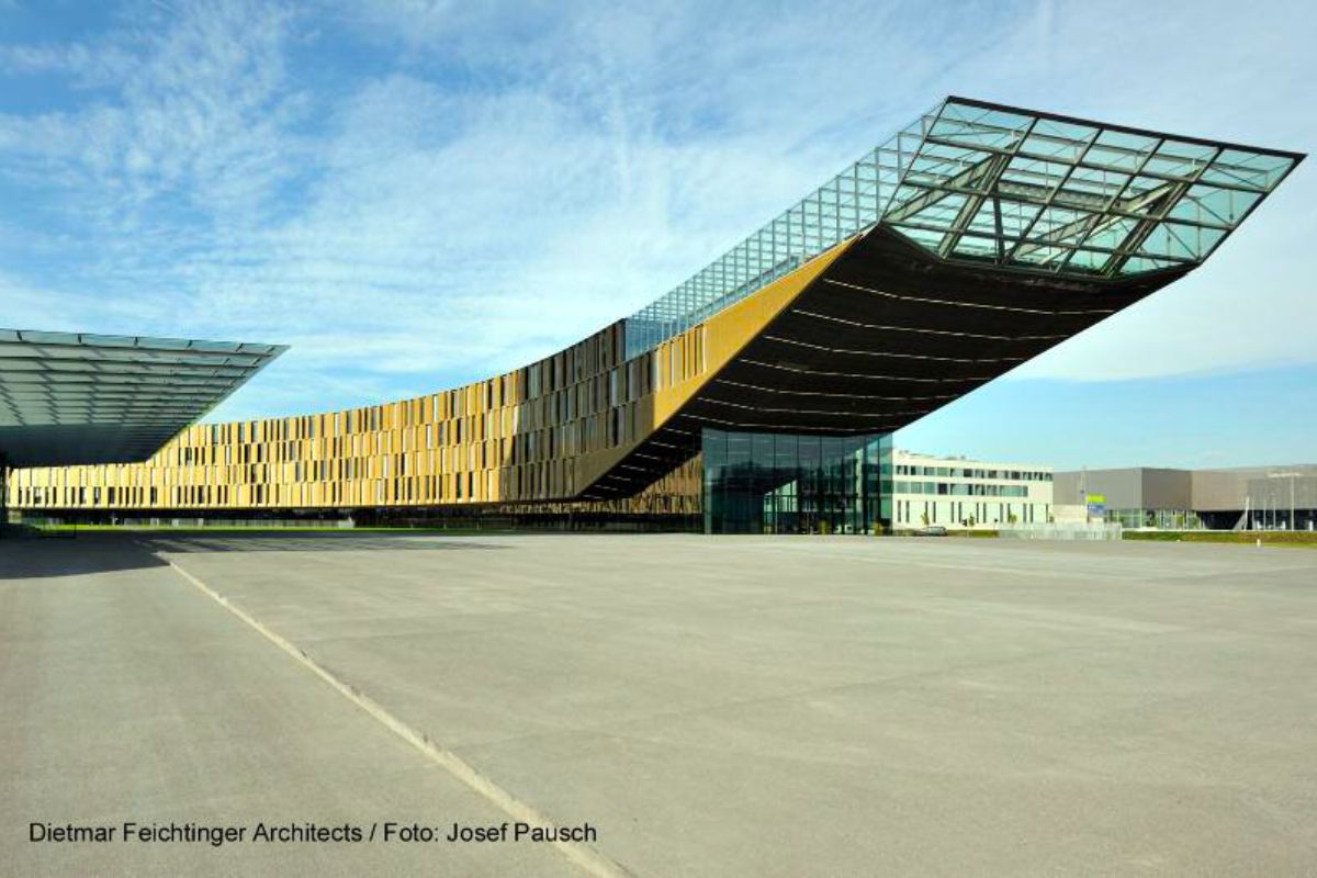 Modernes Gebäude mit auskragender Stahl-Glas-Konstruktion und geschwungener Fassade
